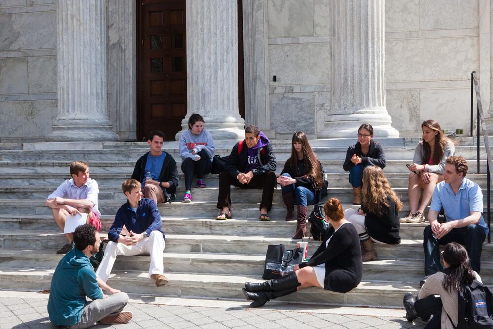 Students sitting on the steps of Whig Hall